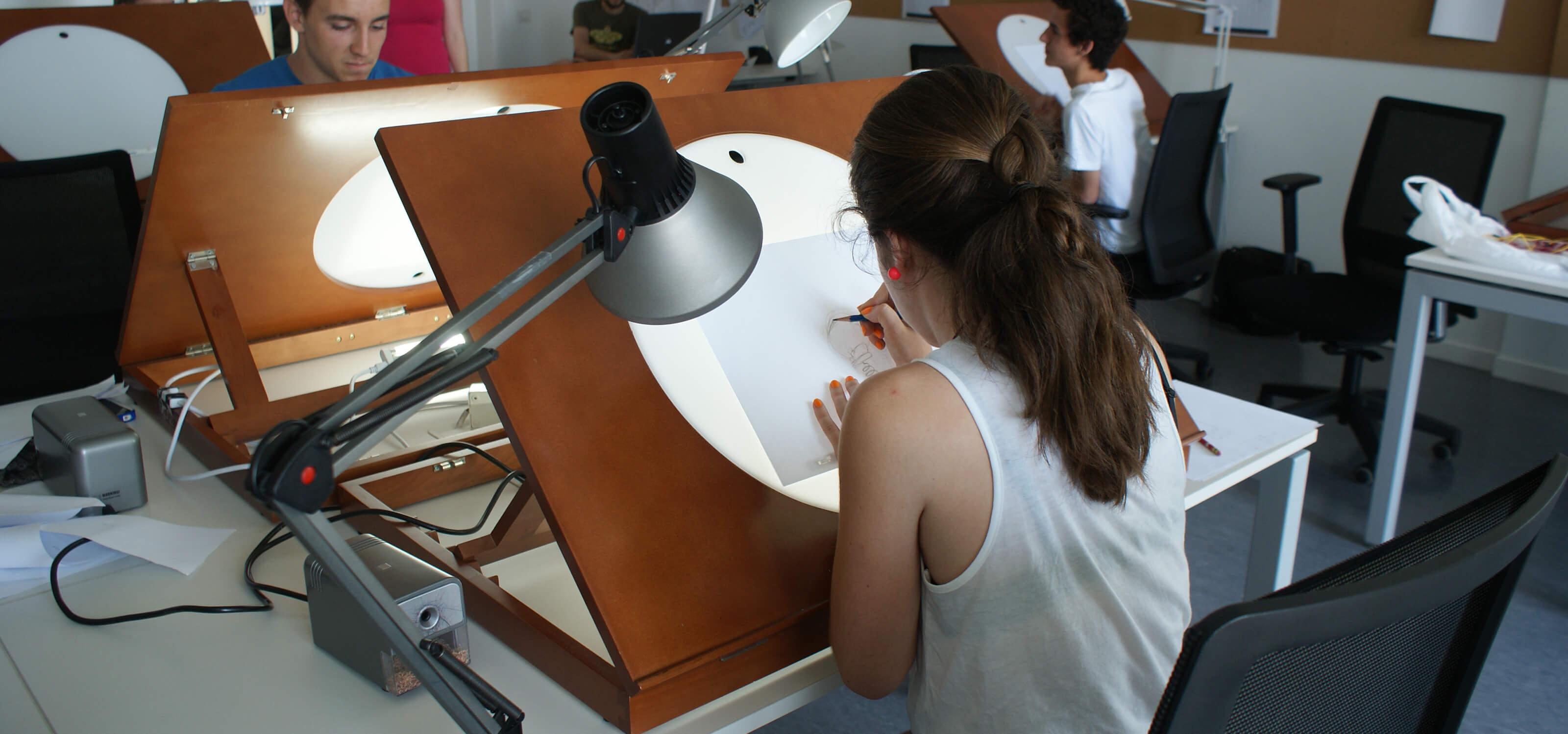 Una estudiante de DigiPen Bilbao trabaja en sus animaciones sobre una mesa de luz.