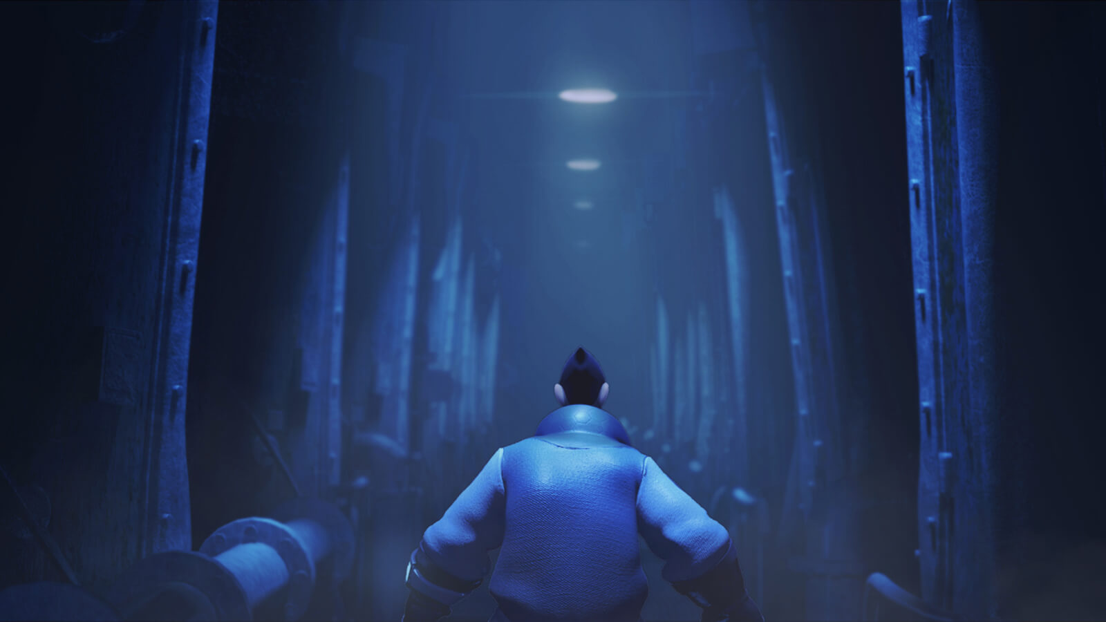 Seen from behind, a man in blue attire walks down an industrial corridor dimly lit from above