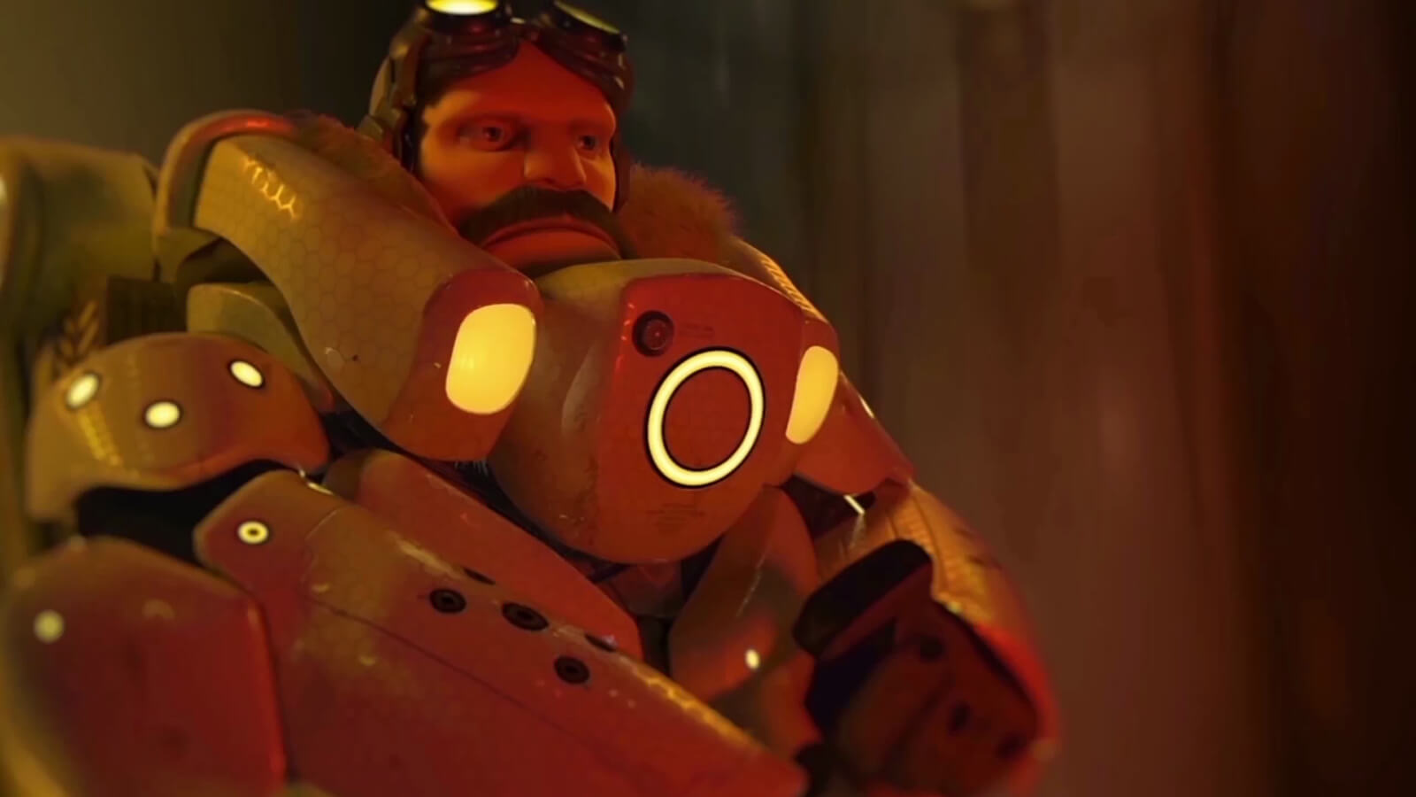 A bearded man wearing goggles and futuristic armor accented with orange lights looks ahead