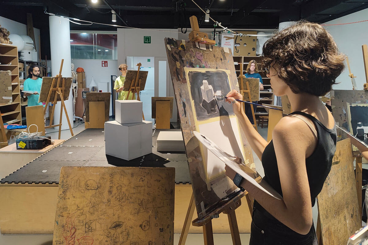 A BFA student paints on an easel.