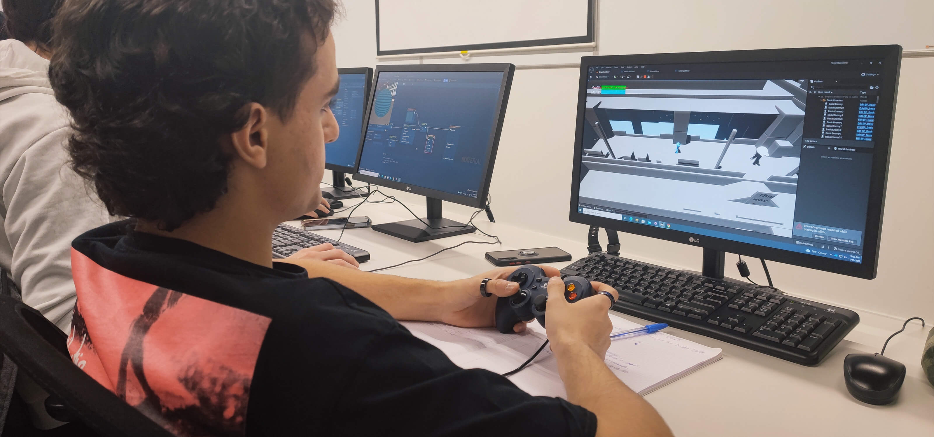 A student uses a controller to test an early build of a video game he is working on.