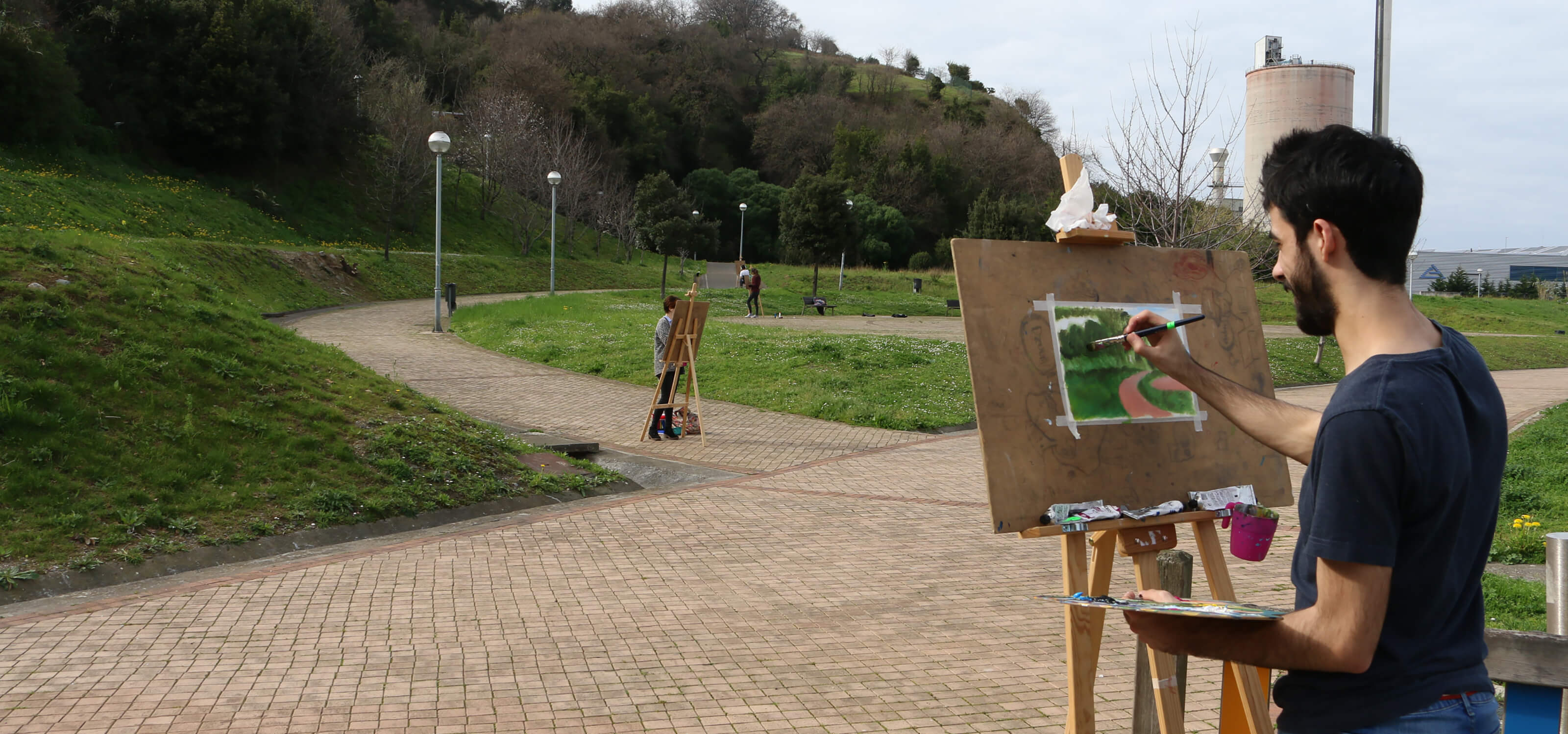 Alumnos de DigiPen Europe-Bilbao pintan en caballetes en un parque.