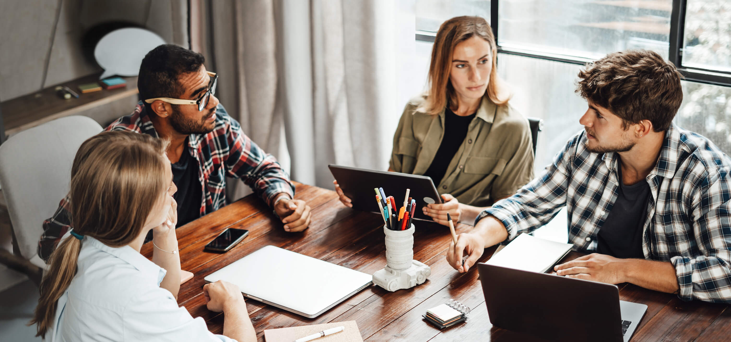 Four people having a meeting at a table.