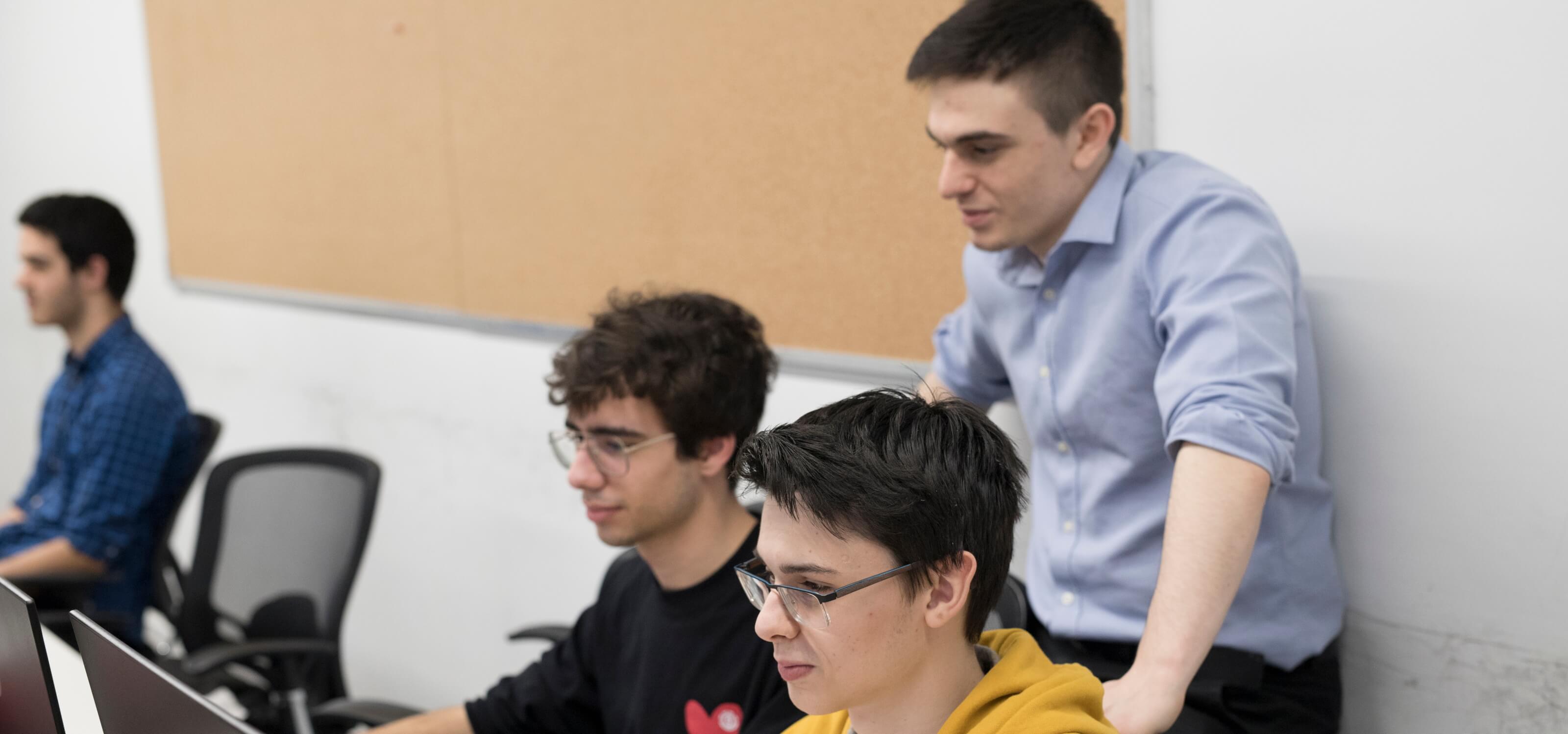 Three students look on and stay focused on their task.