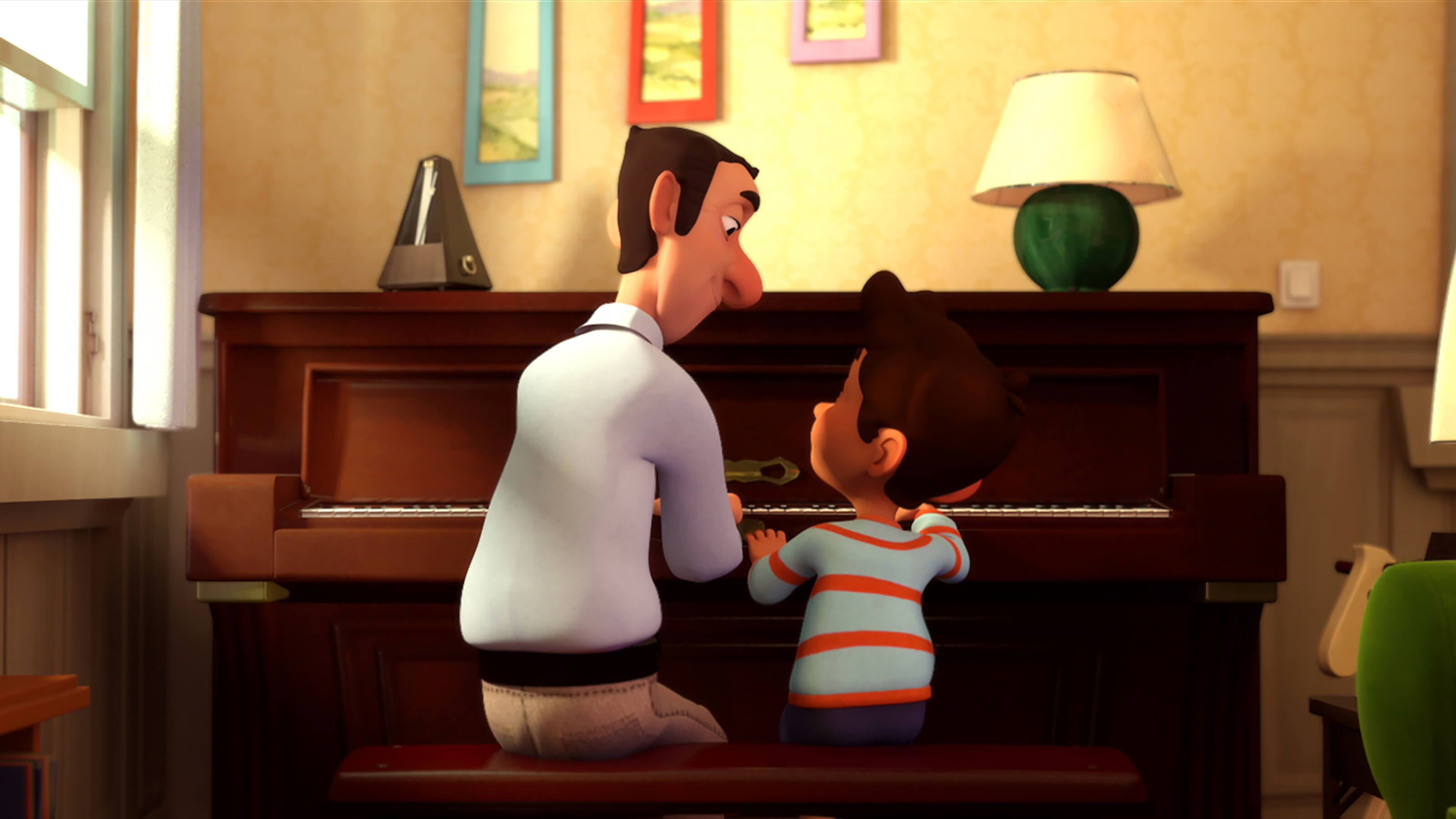 The backs of a man in a white shirt and a boy in a blue and red striped t-shirt as they sit at a brown wooden upright piano