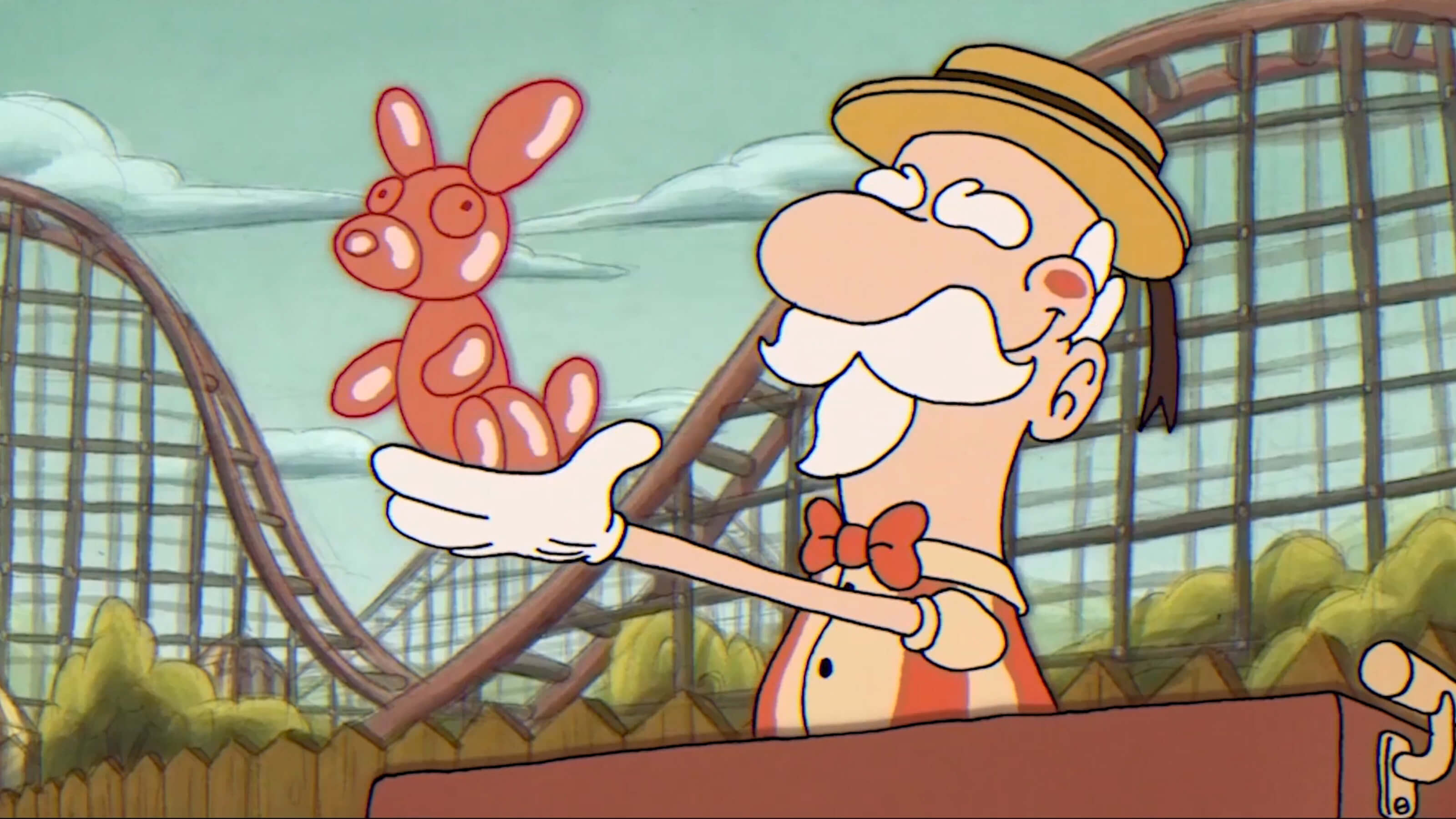 ﻿An old carnival balloonman holds up a red balloon dog ﻿at an amusement park with a roller coaster