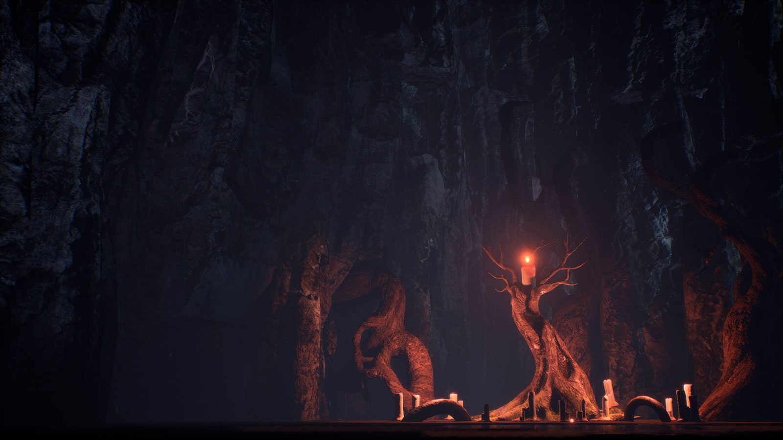 Una extraña masa de raíces sosteniendo unas velas en el fondo de una enorme cueva oscura.