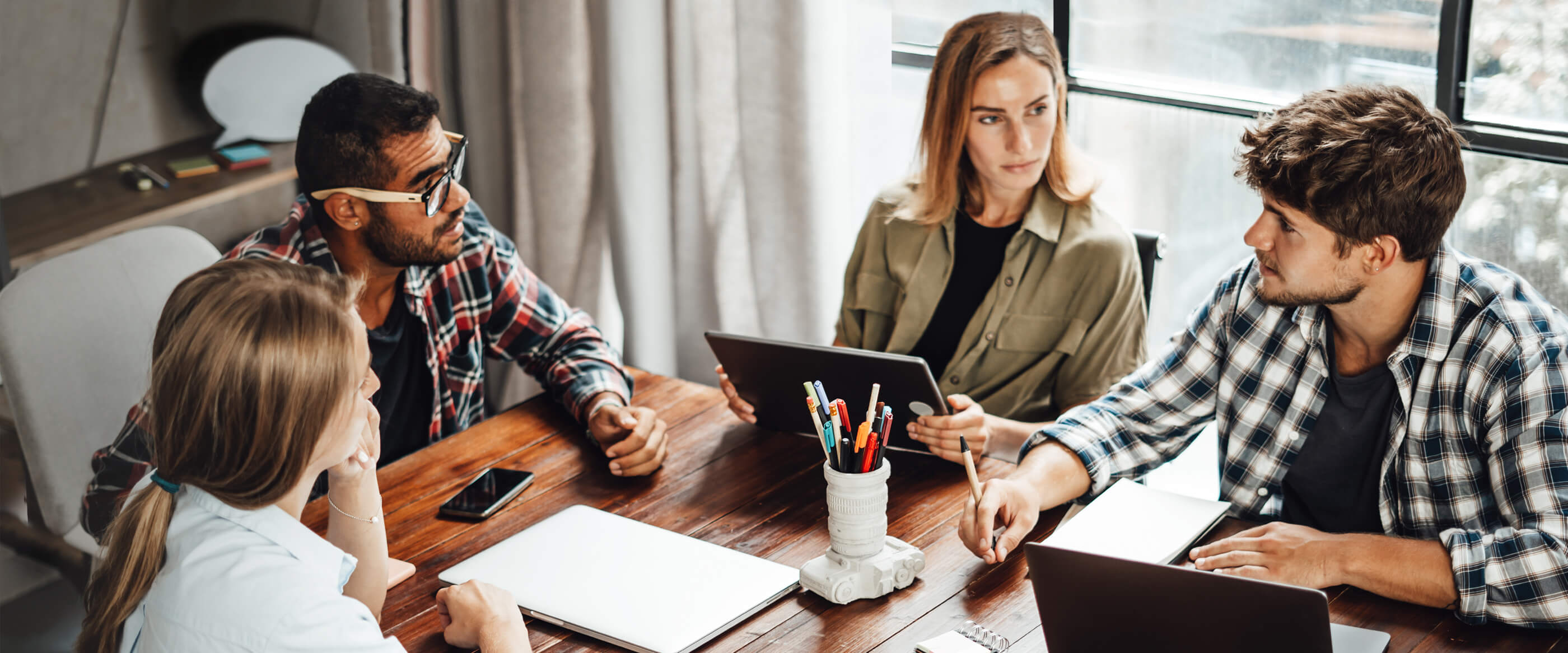 Four people having a meeting at a table.