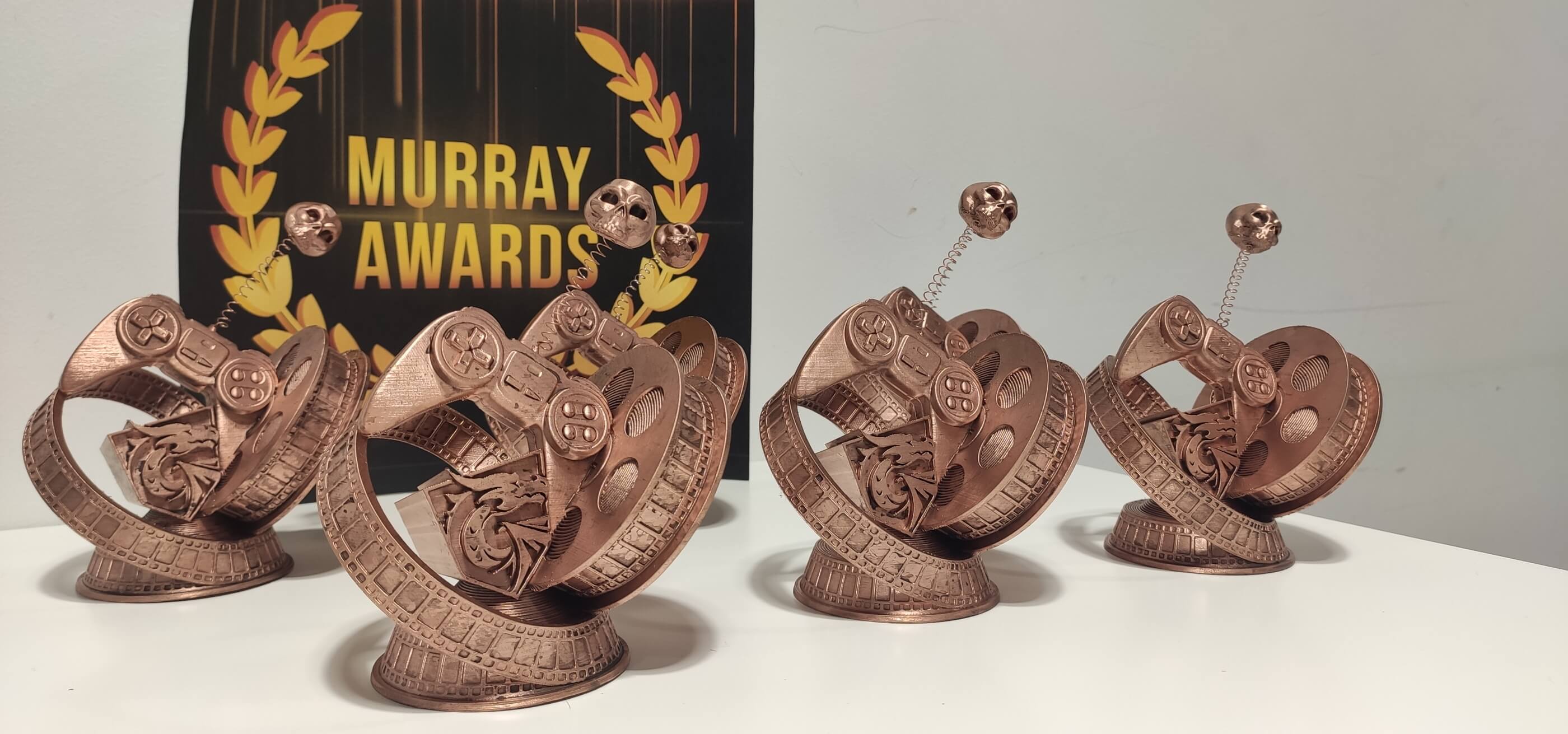 Cinco Murray Awards posados delante del logotipo oficial de los Murray Awards