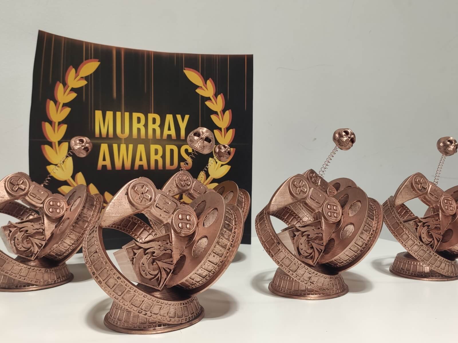 Five Murray Awards stand in front of the official Murray Awards logo