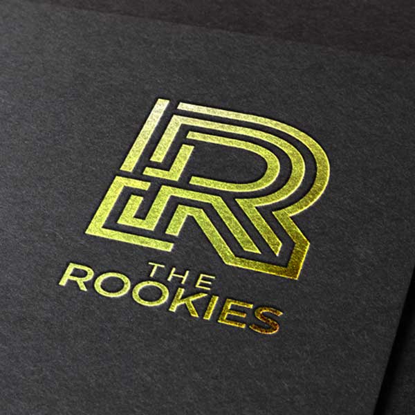Logotipo dorado de ROOKIES estampado en pergamino negro
