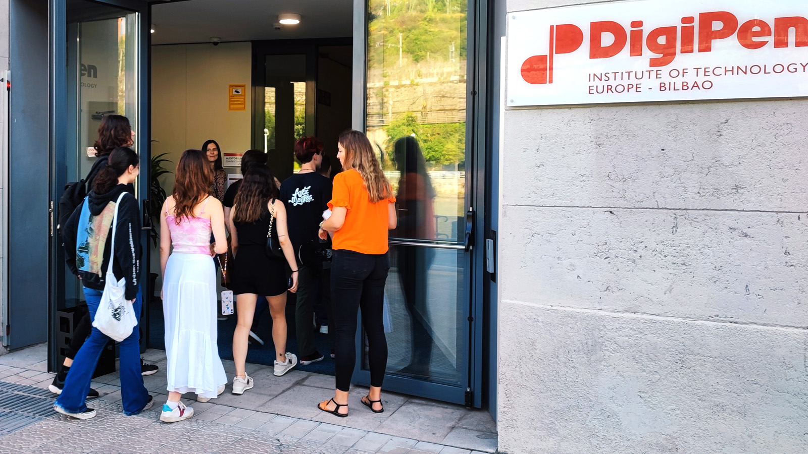 Alumnado de primer curso en la entrada de Digipen Europe-Bilbao atendidos por el personal de administración.