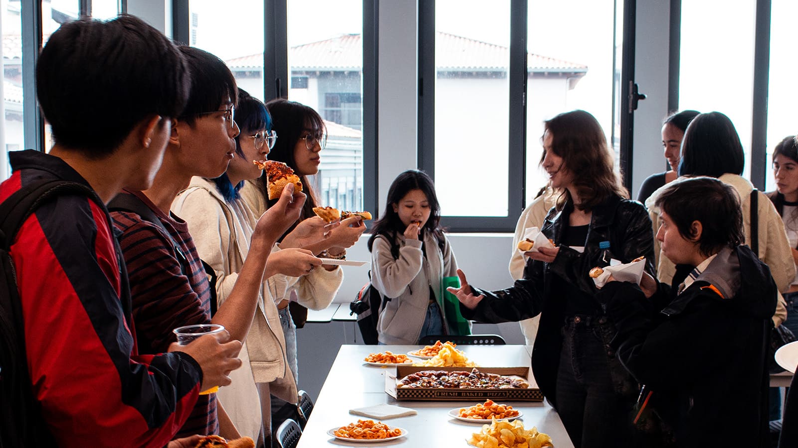 Host students and guest students are sharing food and drinks at the meet and greet event from OIP at DigiPen Europe-Bilbao campus.