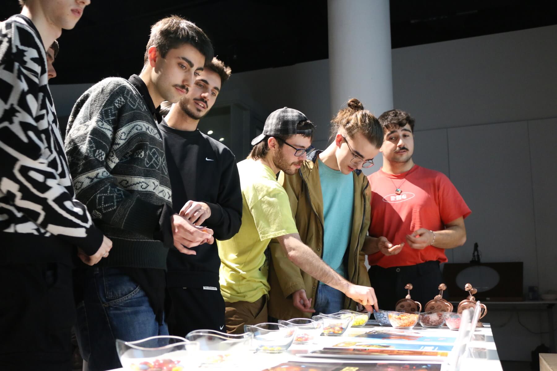 A group of students view a selection of posters depicting various student film projects.