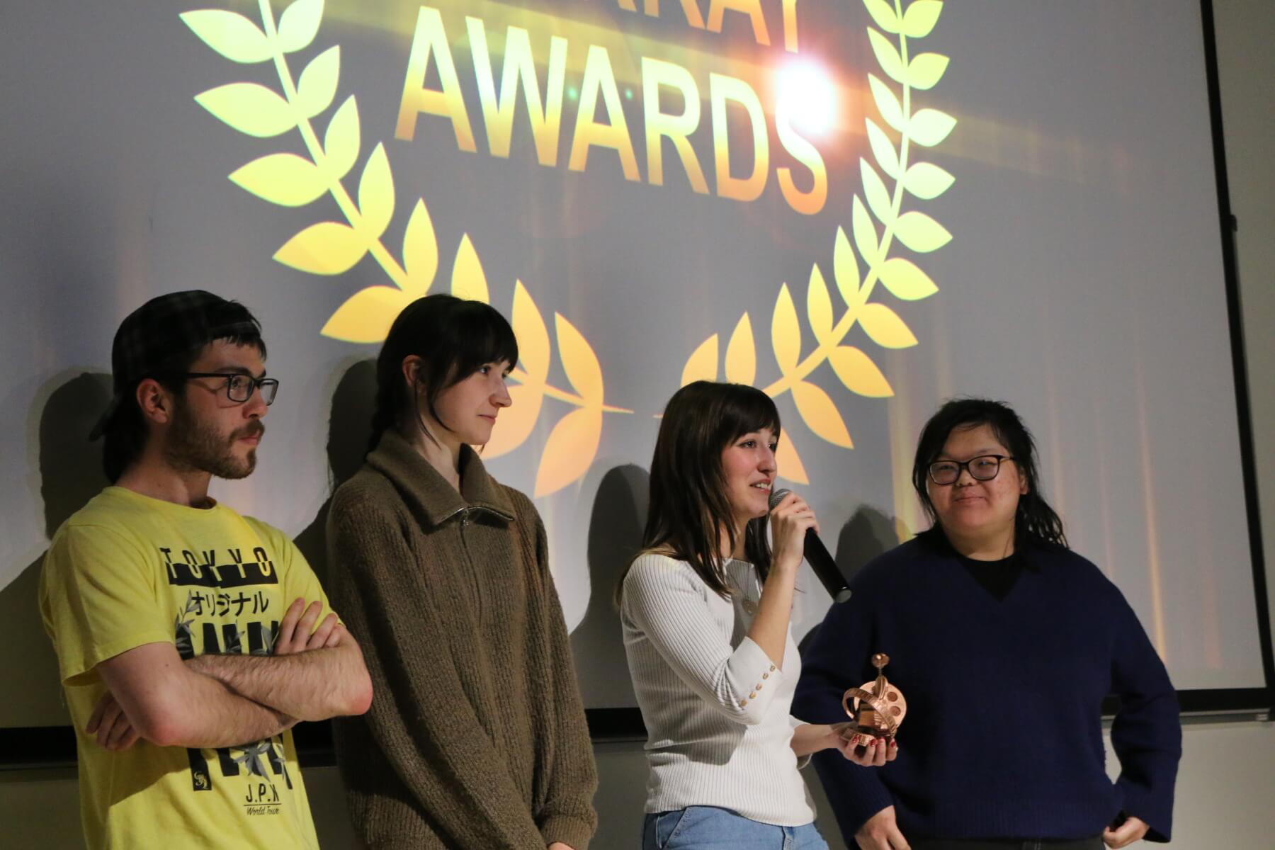 Un equipo de cine estudiantil habla durante el espectáculo de premios tras recibir un galardón